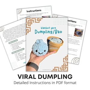 May include: A crochet pattern document titled Blanket Yarn Dumpling/Bao featuring a light blue plush dumpling with a smiling face and a small round cardboard soup container, displayed alongside printed instructional pages with text and diagrams.