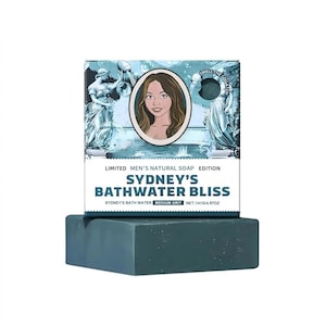 May include: A teal-colored soap bar with a matching box featuring a woman's portrait and the text "Sydney's Bathwater Bliss." The box has a decorative border with statues and the words "Limited Men's Natural Soap Edition."