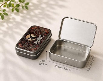 May include: A rectangular metal tin, partially open, with a hinged lid. The lid features a decorative design with the word "BUSHCRAFT". The tin measures 3.94 inches long, 2.17 inches wide, and 0.79 inches high.