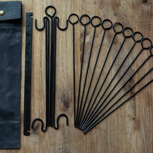 May include: A set of 10 black metal skewers with a canvas carrying case. The skewers have a loop at one end and a pointed end.