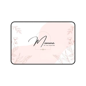 Può includere: Un'illustrazione digitale rosa e bianca con un motivo floreale e il testo "Momma in the Making".