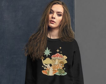 May include: Black sweatshirt with a retro-style illustration of mushrooms, a frog, and stars. The mushrooms are red, brown, and white. The frog is green. The stars are yellow.