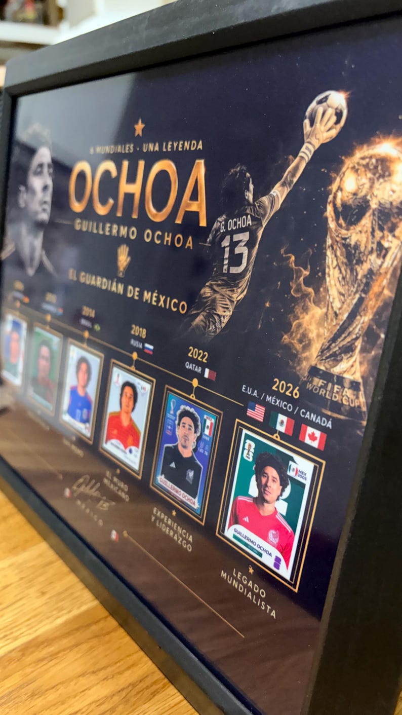 May include: A framed commemorative poster featuring Guillermo Ochoa, with gold text reading OCHOA, 5 MUNDIALES - UNA LEYENDA, and EL GUARDI&Aacute;N DE M&Eacute;XICO. It displays a goalkeeper silhouette, the FIFA World Cup trophy, and a timeline of player cards from 2006 to 2026.