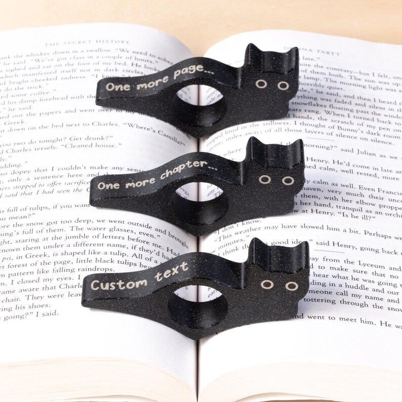 Black cat thumb book page holder with bookmark, ergonomic and playful design, perfect gift for book lovers, adds charm to reading, ideal for birthdays, anniversaries, or as a stocking stuffer, a practical and adorable reading companion