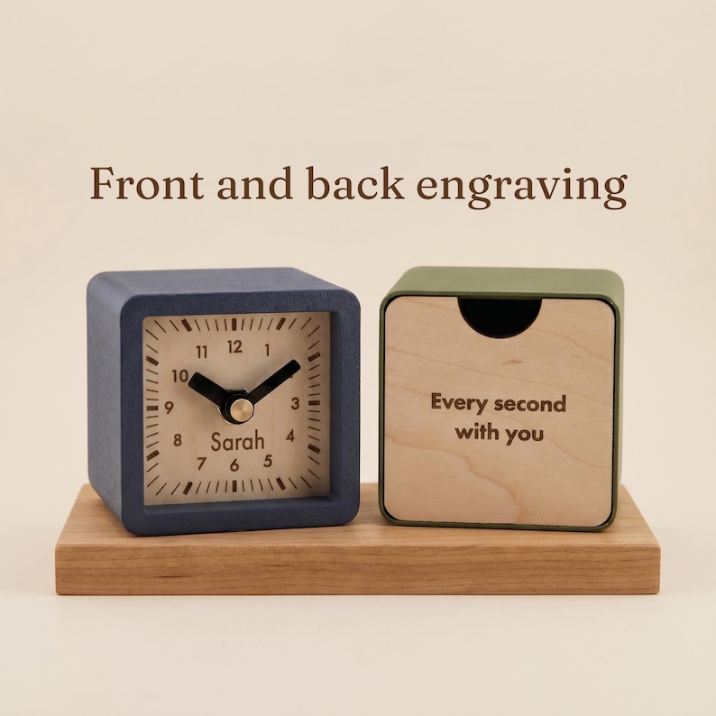 May include: A blue square analog clock with the name Sarah printed on the face and a green square wooden block with the text Every second with you, both resting on a rectangular wooden base. The text Front and back engraving is visible.