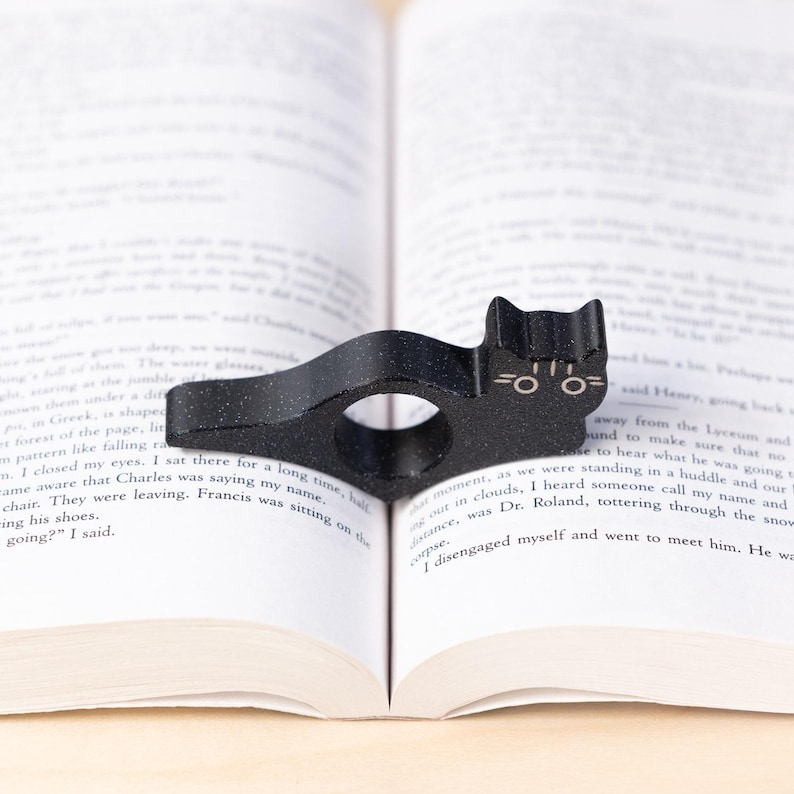 Black tabby cat thumb book page holder with bookmark, ergonomic and playful design, perfect gift for book lovers, adds charm to reading, ideal for birthdays, anniversaries, or as a stocking stuffer, a practical and adorable reading companion