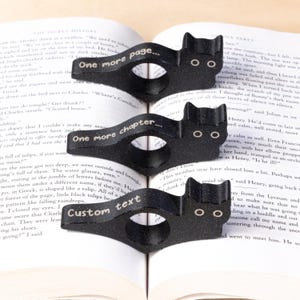 Black cat thumb book page holder with bookmark, ergonomic and playful design, perfect gift for book lovers, adds charm to reading, ideal for birthdays, anniversaries, or as a stocking stuffer, a practical and adorable reading companion