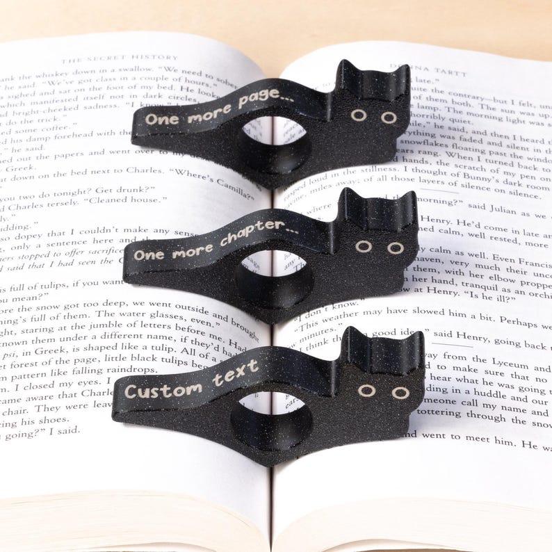 Black cat thumb book page holder with bookmark, ergonomic and playful design, perfect gift for book lovers, adds charm to reading, ideal for birthdays, anniversaries, or as a stocking stuffer, a practical and adorable reading companion