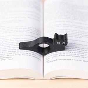 Black cat thumb book page holder with bookmark, ergonomic and playful design, perfect gift for book lovers, adds charm to reading, ideal for birthdays, anniversaries, or as a stocking stuffer, a practical and adorable reading companion