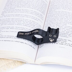 Black tuxedo cat thumb book page holder with bookmark, ergonomic and playful design, perfect gift for book lovers, adds charm to reading, ideal for birthdays, anniversaries, or as a stocking stuffer, a practical and adorable reading companion