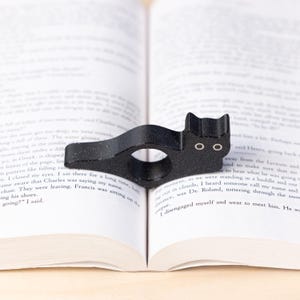 Black cat thumb book page holder with bookmark, ergonomic and playful design, perfect gift for book lovers, adds charm to reading, ideal for birthdays, anniversaries, or as a stocking stuffer, a practical and adorable reading companion