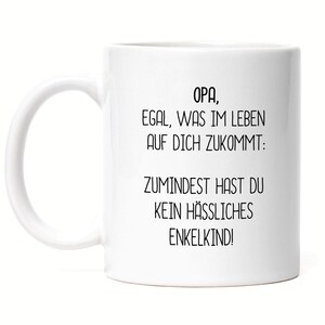 May include: White ceramic mug with a curved handle. The mug features black text that reads "OPA, EGAL, WAS IM LEBEN AUF DICH ZUKOMMT: ZUMINDEST HAST DU KEIN HÄSSLICHES ENKELKIND!"