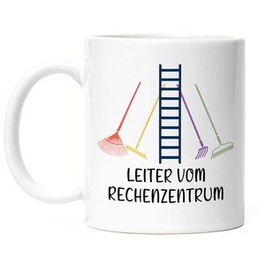 Könnte beinhalten: Weiße Keramik-Tasse mit einem Design, das eine dunkelblaue Leiter, vier farbige Rechen und den Text "LEITER VOM RECHENZENTRUM" in Schwarz zeigt. Die Tasse hat einen weißen Henkel und ist für heiße oder kalte Getränke geeignet.