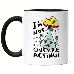 Könnte beinhalten: Eine weiße Keramiktasse mit schwarzem Rand und Henkel. Die Tasse zeigt eine Cartoon-Illustration eines Bechers mit einer roten und gelben Explosion oben. Der Text "I'm not overreacting!" ist in Schwarz unter dem Becher aufgedruckt.