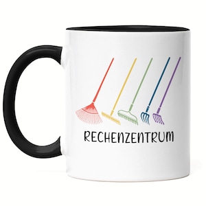 Könnte beinhalten: Weiße Kaffeetasse mit schwarzem Rand und Henkel. Die Tasse hat eine bunte Illustration von fünf Rechen und den Text "Rechenzentrum" auf der Vorderseite.