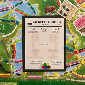 Op de afbeelding: Een Ticket to Ride bordspel met een speelbord, treinwagons en bestemmingskaarten. Het speelbord is een kaart van de Great Lakes regio in Noord-Amerika. Het spel is voor 2-5 spelers en is een populair familiespel.
