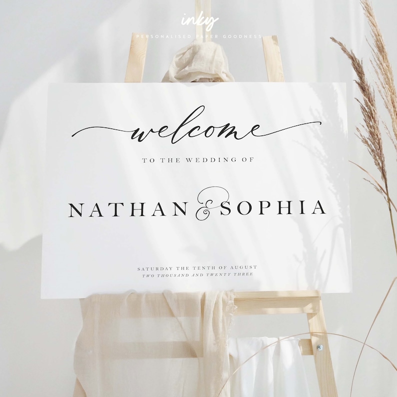 May include: White wedding welcome sign with black calligraphy text that reads "Welcome to the wedding of Nathan & Sophia" and "Saturday the tenth of August, Two thousand and twenty three".