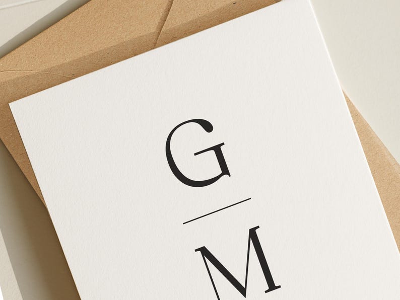 May include: A white card with a black monogram of the letters "G" and "M" with a line separating the letters.