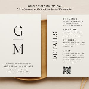 May include: A double-sided wedding invitation with a minimalist design. The front features the initials "G" and "M" in a serif font. The back includes details about the venue, reception, children, and gifts. The text reads "THE VENUE", "RECEPTION", "CHILDREN", and "GIFTS".