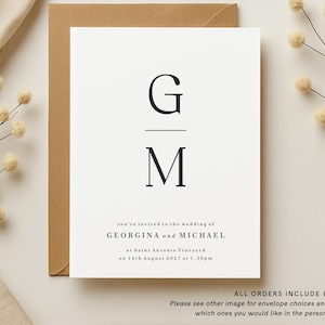 May include: A minimalist wedding invitation with a black and white design. The invitation features the couple's initials, "G" and "M", in a simple, elegant font. The text reads "you're invited to the wedding of GEORGINA and MICHAEL at Saint Antonis Vineyard on 14th August 2027 at 1:30pm".