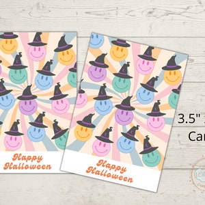 Puede incluir: Dos tarjetas de 3,5" x 5" con un fondo colorido y giratorio con caras sonrientes que llevan sombreros de bruja. El texto "Happy Halloween" está impreso en cada tarjeta.