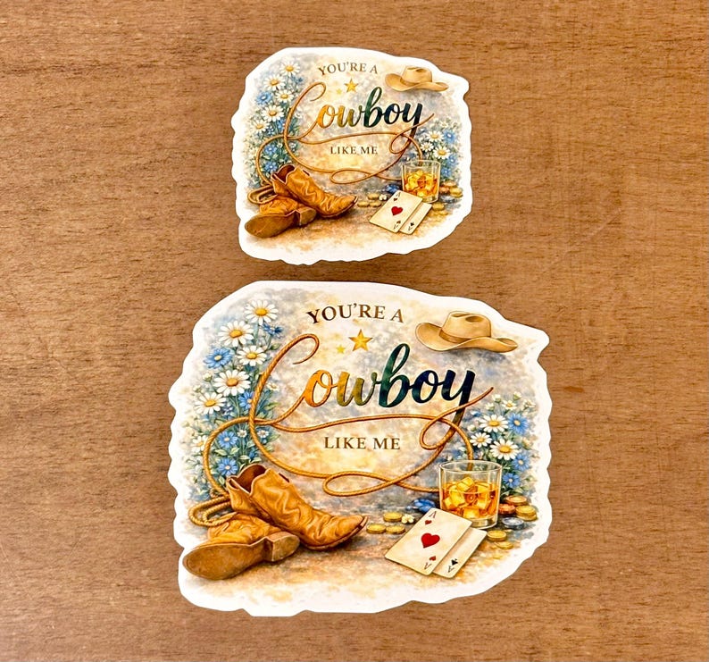 May include: Two stickers with a cowboy theme. Each sticker features a cowboy hat, boots, playing cards, and a glass of whiskey. The text "You're a Cowboy Like Me" is written in a decorative font, surrounded by flowers.