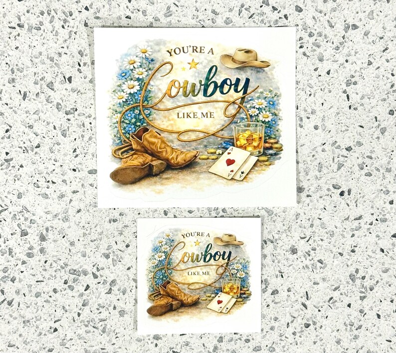 May include: A cowboy-themed print with the text "You're a Cowboy Like Me." The image features cowboy boots, a hat, playing cards, and a glass of amber liquid. The design includes a floral arrangement and gold accents.