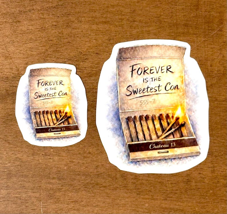 May include: Two stickers on a wooden surface. One sticker shows a matchbox with the text "FOREVER IS THE Sweetest Con" and "Chateau 13". The other sticker is a smaller version of the same image.