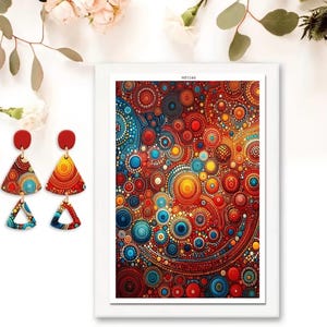 May include: A pair of red and patterned earrings, alongside a framed abstract artwork. The earrings have a red circular top and a triangle shape with a colourful pattern. The artwork features a vibrant, circular pattern in red, blue, and yellow.