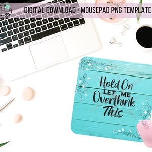 May include: A turquoise blue mousepad with a white woodgrain background and white floral accents. The text "Hold On Let Me Overthink This" is printed in black on the mousepad.