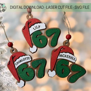 May include: Wooden Christmas ornaments with the names "Lily", "Charlotte", and "McKenna" on them. Each ornament features a red Santa hat and the number "67" in green. The ornaments are laser cut and include the text "DIGITAL DOWNLOAD · LASER CUT FILE · SVG FILE".