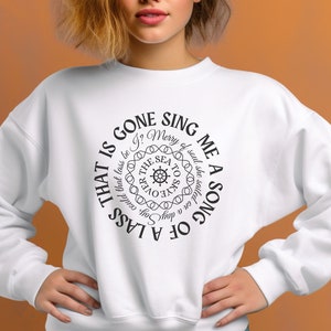 May include: White sweatshirt with a black graphic design of a nautical compass with the text "That is gone sing me a song of a lass" around the compass.
