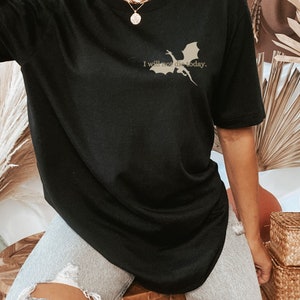 May include: Black oversized t-shirt with a silhouette of a dragon and the text "I will not die today."