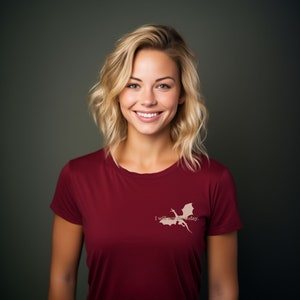 May include: A woman with blonde hair is wearing a maroon t-shirt with a white dragon graphic and the text "I will not die today."
