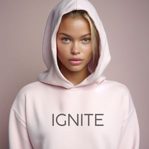 Puede incluir: Una sudadera con capucha rosa con la palabra "IGNITE" impresa en negro en la parte delantera.