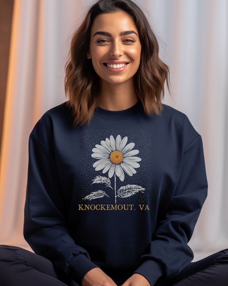 Puede incluir: Sudadera azul marino con un gr&aacute;fico de margarita blanca y el texto "Knockemout, VA".