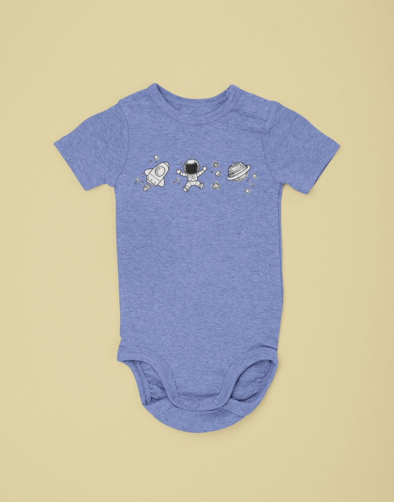 May include: A light blue baby onesie with a white astronaut, rocket, and planet design.