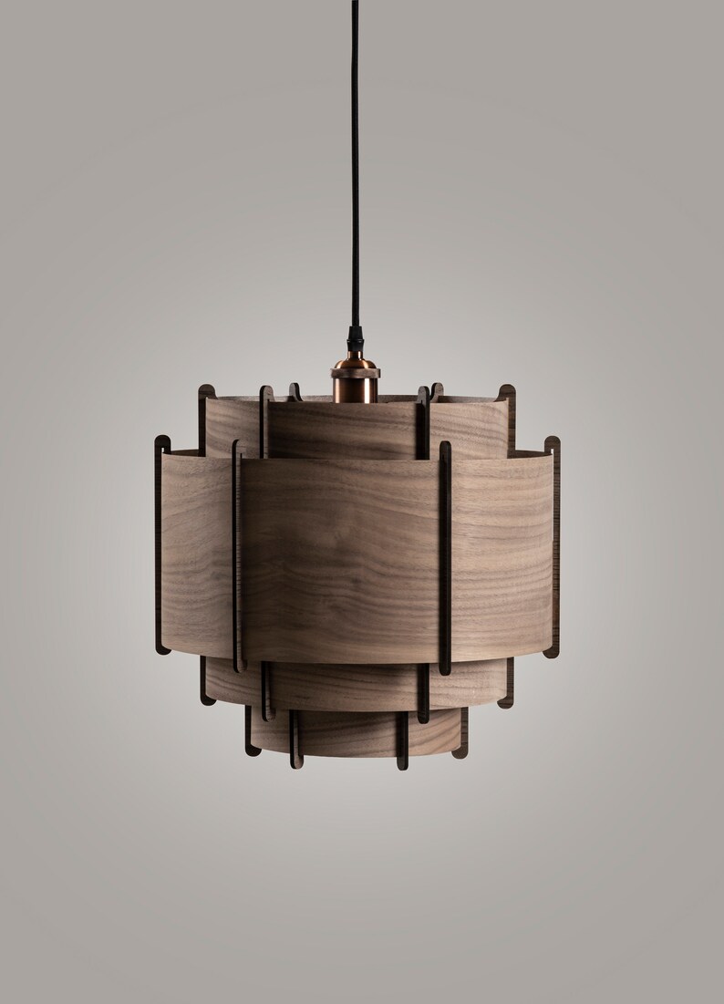 May include: A wooden pendant light with a layered, geometric design. The light fixture is made of multiple pieces of wood that are stacked on top of each other to create a unique and modern look.