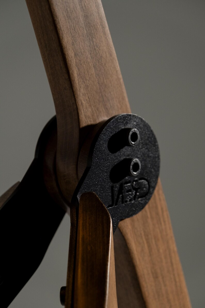 Pu&ograve; includere: Primo piano di una pala di elica in legno con finitura marrone scuro, collegata a un mozzo in metallo nero. Il mozzo ha due fori e il testo "JAE" &egrave; visibile. Le pale sono angolate, suggerendo una ventola o un elemento decorativo.