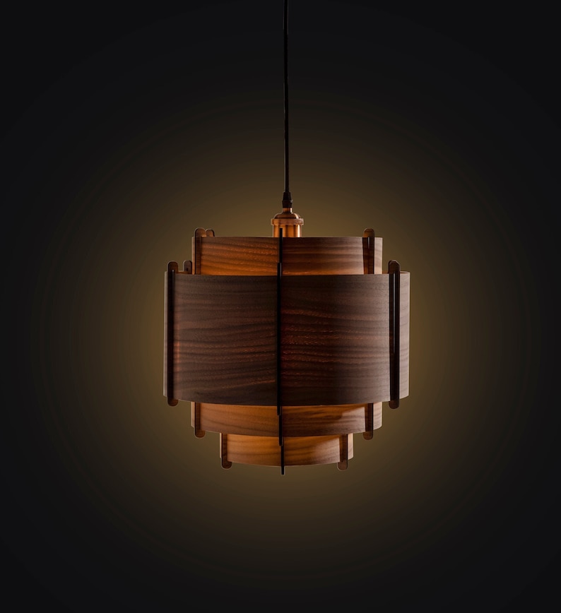 May include: A wooden pendant light with a warm, glowing light bulb. The light fixture is made of multiple layers of wood, creating a unique and modern design.