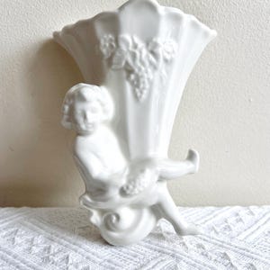 Könnte beinhalten: Ein Set aus drei Keramikbechern mit gesprenkelter, matter Oberfläche. Die Becher sind in Creme-, Hellgrau- und Dunkelgrautönen gehalten. Jeder Becher hat ein schlichtes, minimalistisches Design.