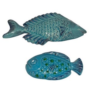 Peut inclure: Deux sculptures de poissons en céramique turquoise. Le poisson supérieur est allongé avec des écailles et des nageoires détaillées. Le poisson inférieur est plus rond, avec des accents verts et une expression souriante. Décoratif.