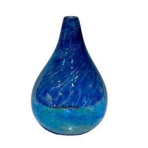 May include: A small, teardrop-shaped glass vase with a blue and green swirl pattern. The vase is made of clear glass with a blue and green iridescent finish.