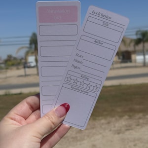 Könnte beinhalten: Zwei weiße Lesezeichen mit Text und Linien für Anmerkungen und Buchbesprechungen. Ein Lesezeichen hat den Text "Annotation Key" in einem rosa Feld. Das andere Lesezeichen hat Felder für "Title", "Author", "Start", "Finish", "Pages", "Rating" und "Favorite Quote".