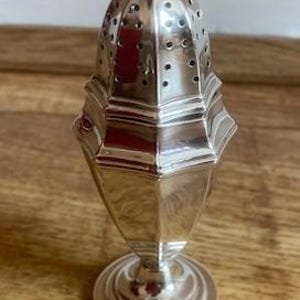 May include: A silver sugar shaker with a domed top and a pierced design. The shaker has a hexagonal base and a round, fluted foot.