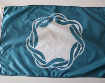 May include: A teal blue flag with a white, stylized, circular design. The design is a series of interlocked loops.