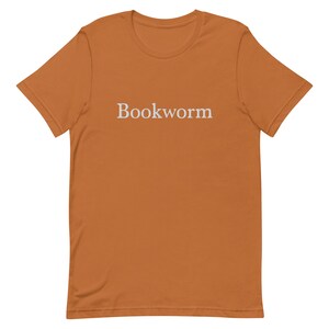 May include: A brown t-shirt with the word "Bookworm" embroidered in white on the front.