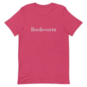 May include: A pink heather t-shirt with the word "Bookworm" printed in white on the front.