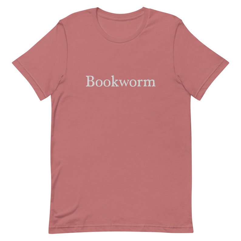 May include: A pink t-shirt with the word "Bookworm" printed in white on the front.