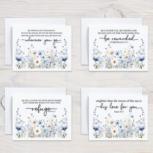 May include: Four greeting cards with white envelopes. Each card features a floral design in blue and white, with inspirational quotes in black script. The cards are arranged on a light wood surface.